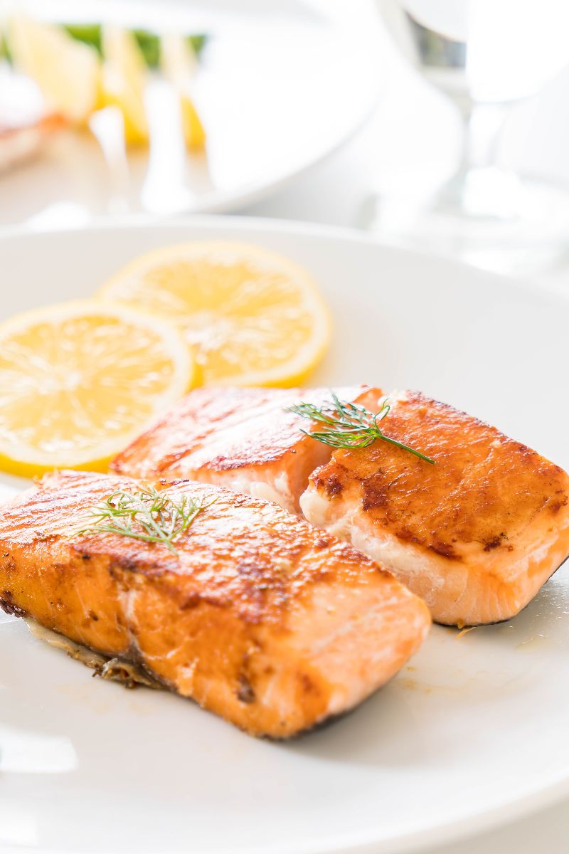 two filets of salmon on a plate with lemon slices