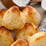 a stack of macaroon cookies with a halved coconut in the background
