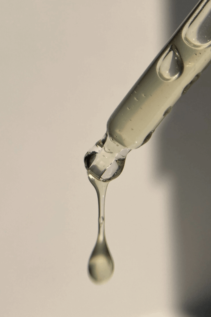 Skincare dripping out of a dropper.