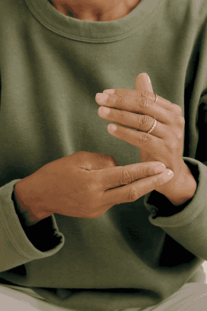 Close-up of a woman's hands tapping on acupressure points during an EFT tapping session